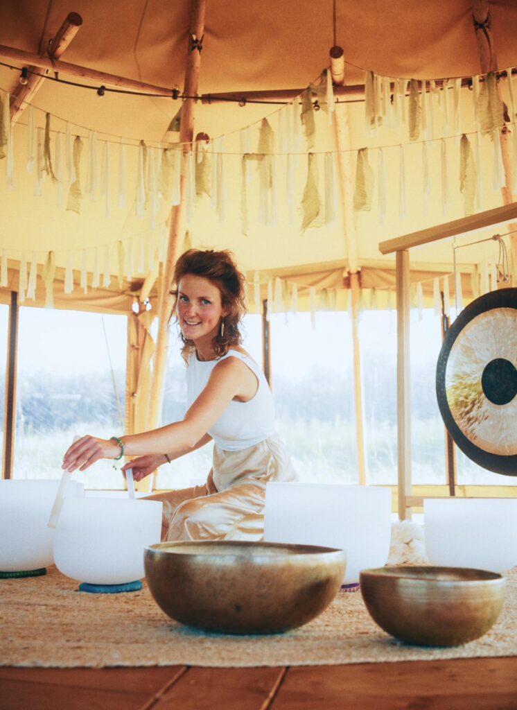Sound healer begeleidt deelnemers met kristallen klankschalen tijdens The Listening Field ceremonie